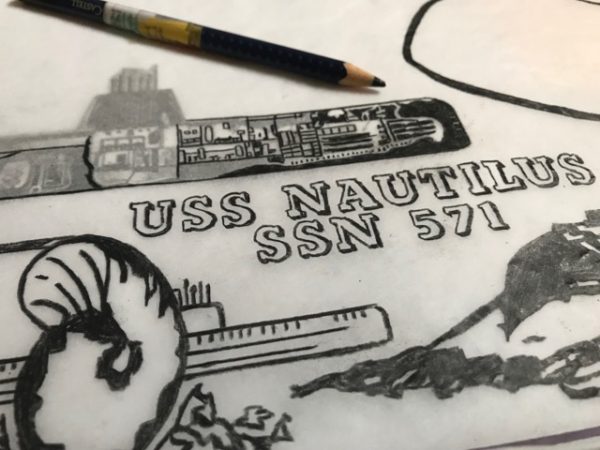 Jonpaul Smith's work in progress, linocut design. A pencil drawing of a shell, some type spelling out: USS NAUTILUS SSN 571, a submarine, and a pencil